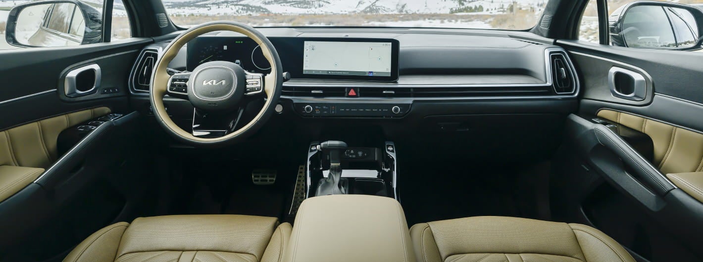 Interior view of a 2026 Kia Sorento dashboard featuring a beige leather interior. The sleek dashboard has a digital display and a stylish steering wheel.